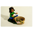Rastafigur vor Grass Korb und baut ein Joint